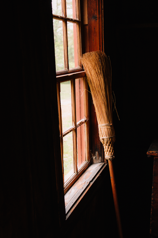 A witches broom standing against a window in Salem, Ma